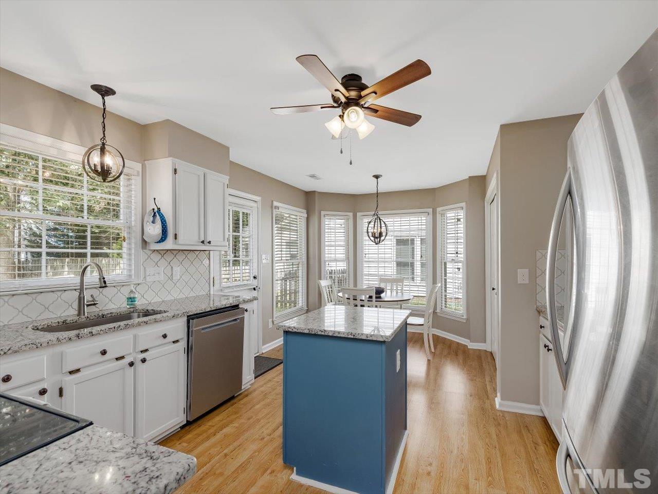 11220 North Radner Way Raleigh, NC 27613 - Photo 8 of 24 a large kitchen with stainless steel appliances a lot of counter space and a window