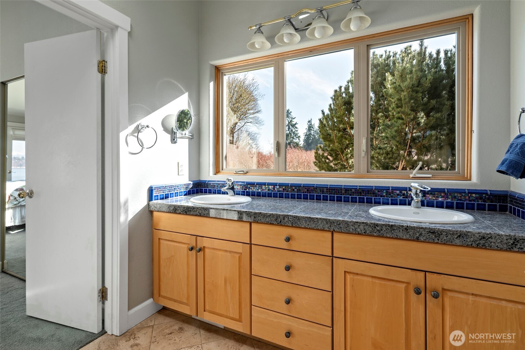 5477 Wilkinson Road Langley, WA 98260 - Photo 22 of 40 a bathroom with a granite countertop sink and next to a window