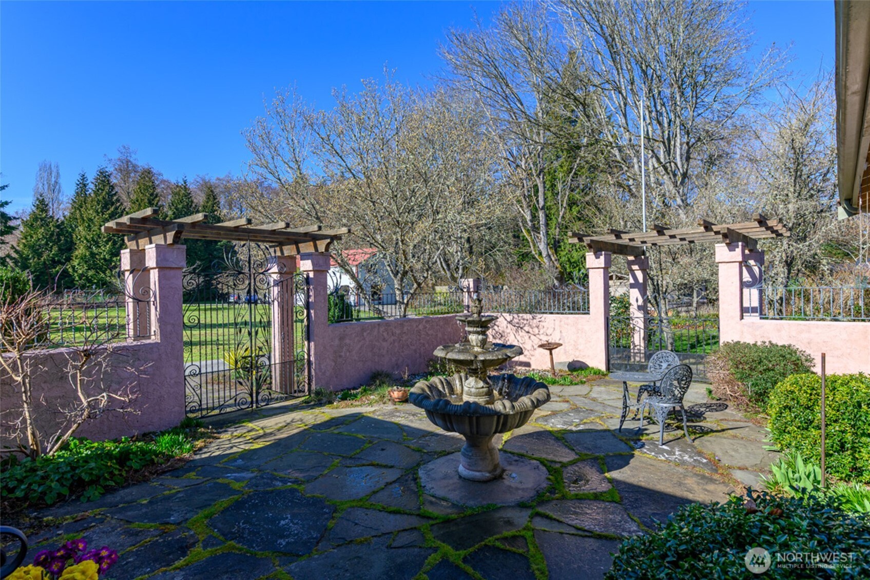 5477 Wilkinson Road Langley, WA 98260 - Photo 5 of 40 a view of a patio with table and chairs potted plants and large tree