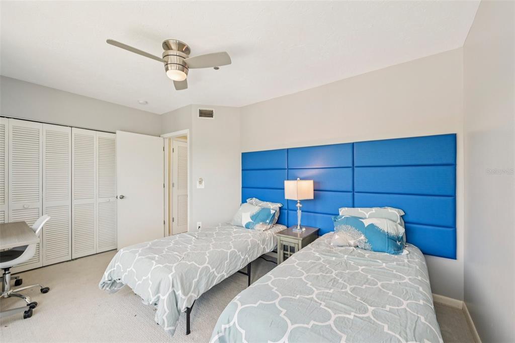 660 Cedars Court Longboat Key, FL 34228 - Photo 14 of 35 a bedroom with two beds and a chandelier