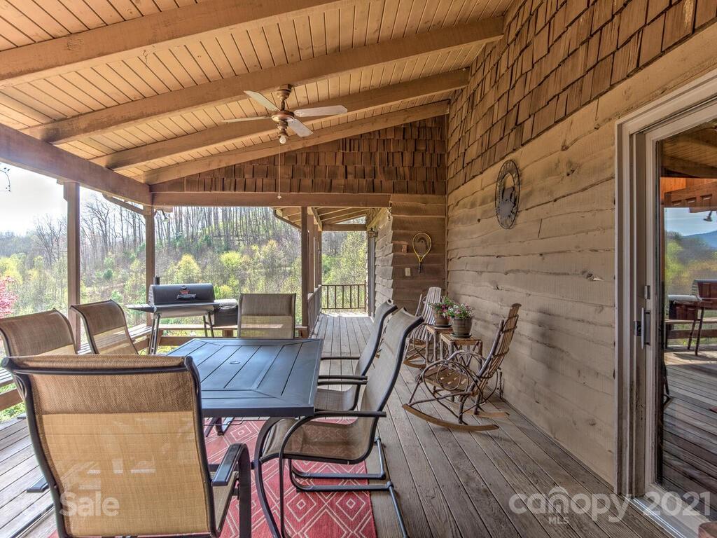 251 Riding High Road Waynesville, NC 28785 - Photo 15 of 41 a view of a dining room with furniture large windows and wooden floor