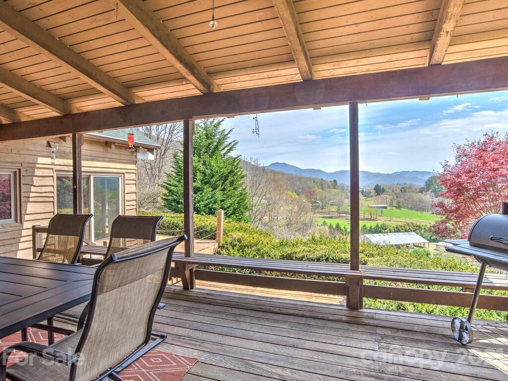 251 Riding High Road Waynesville, NC 28785 - Photo 17 of 41 a view of a patio with a table chairs and wooden fence