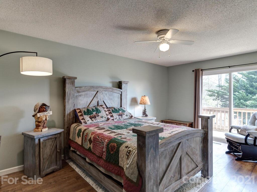 251 Riding High Road Waynesville, NC 28785 - Photo 22 of 41 a bed room with a bed and a chandelier