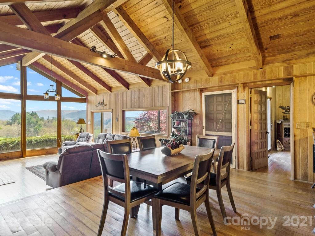 251 Riding High Road Waynesville, NC 28785 - Photo 6 of 41 a view of a dining room with furniture large windows and wooden floor