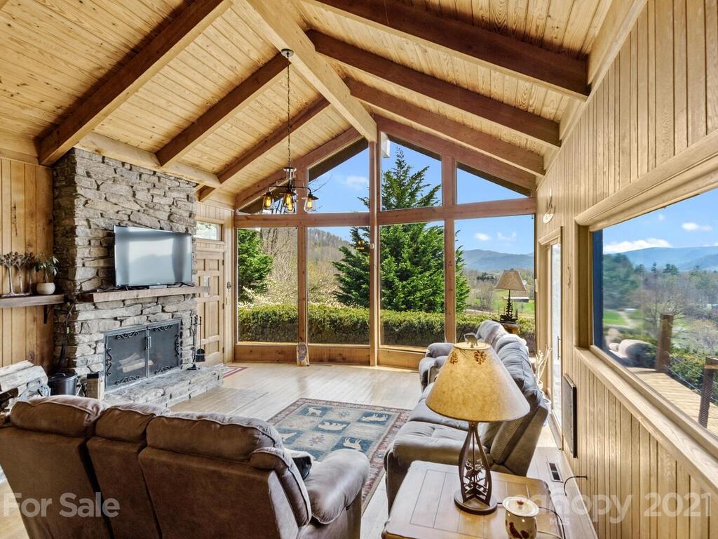 251 Riding High Road Waynesville, NC 28785 - Photo 7 of 41 a living room with furniture a fireplace and a flat screen tv