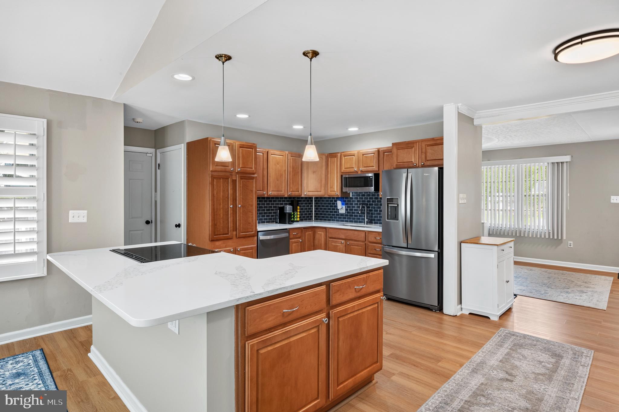 Kitchen with island and warm maple cabinets,