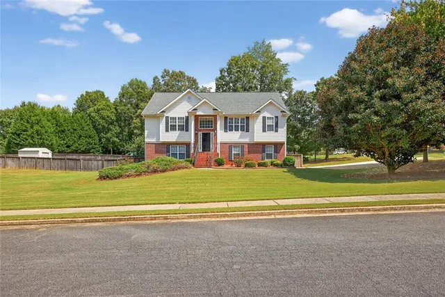 a view of a house with a big yard and palm trees
