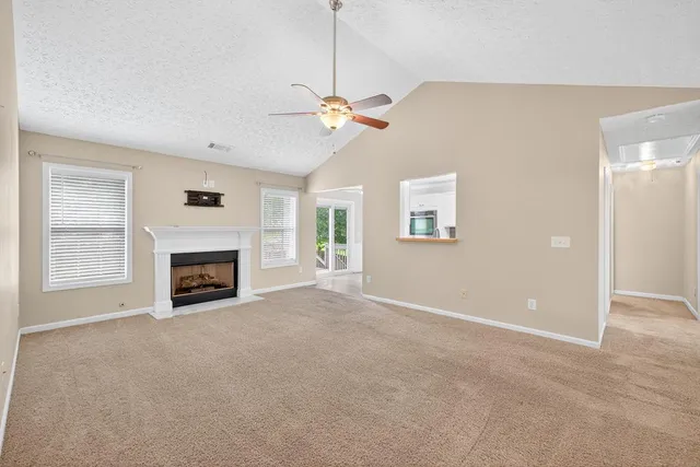 a view of a livingroom with a ceiling fan and a fireplace