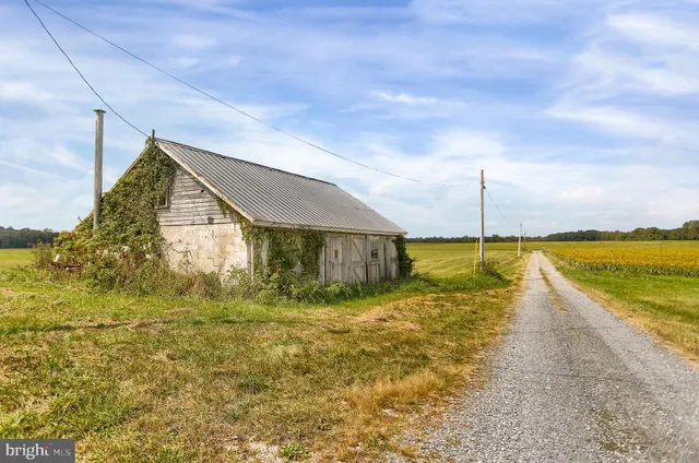 a front view of house with yard and ocean