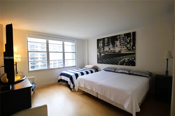 a bedroom with a bed and a flat screen tv
