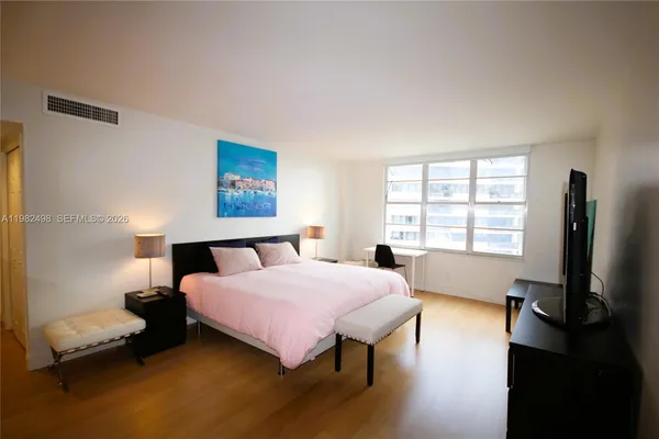 a bedroom with a bed and a flat screen tv