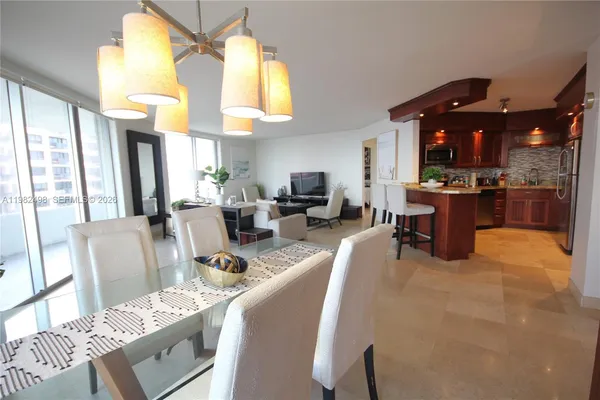 a kitchen with stainless steel appliances kitchen island granite countertop a sink refrigerator and cabinets