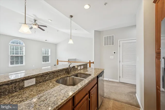 a kitchen with kitchen island granite countertop a sink stainless steel appliances and cabinets