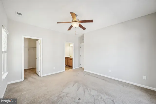 a view of a room with a ceiling fan and a window