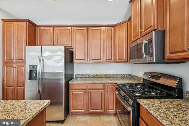a kitchen with stainless steel appliances granite countertop a refrigerator and a sink