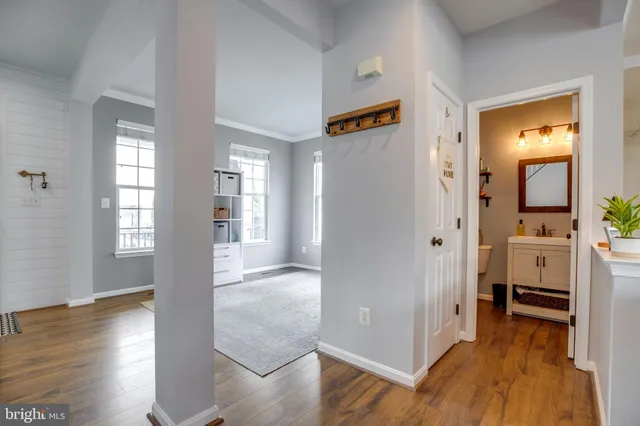 a view of a hallway with bathroom and wooden floor