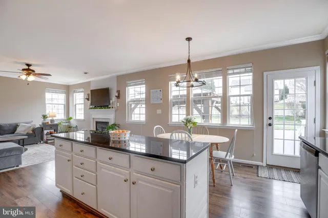 a kitchen with stainless steel appliances granite countertop a stove top oven a sink dishwasher a refrigerator and cabinets with wooden floor