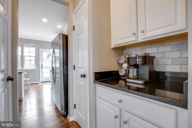 a kitchen with granite countertop a sink dining table and chairs