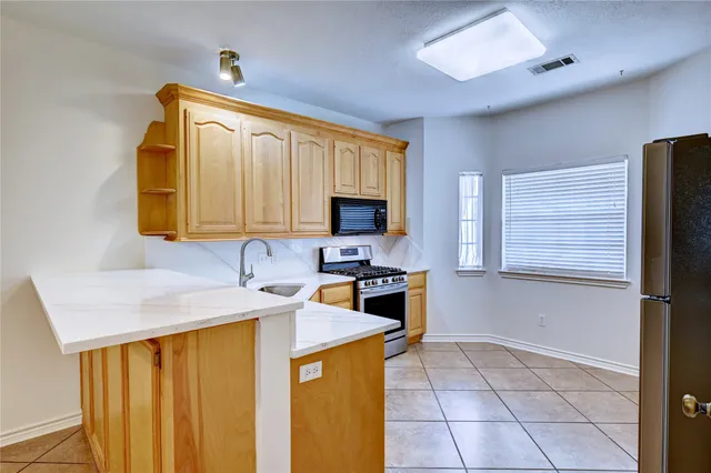 a kitchen with stainless steel appliances granite countertop a sink refrigerator and microwave