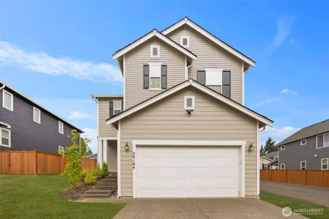 a view of house with a yard and garage