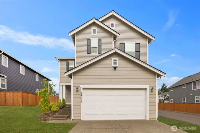 a view of house with a yard and garage