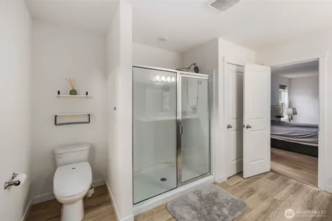a bathroom with a granite countertop toilet a sink and shower