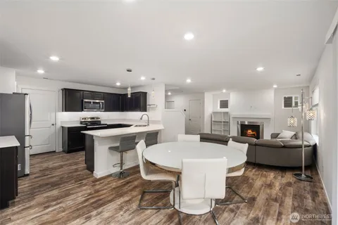 a living room with stainless steel appliances kitchen island granite countertop furniture and a fireplace
