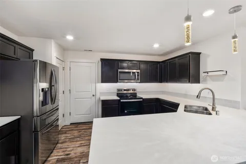 a kitchen with granite countertop a refrigerator and a sink