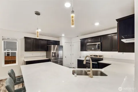 a kitchen with stainless steel appliances a stove a microwave a sink and a refrigerator