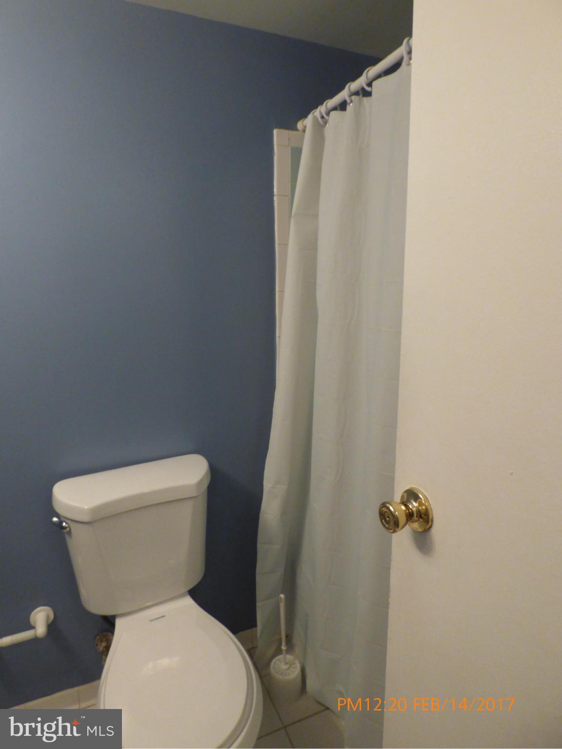 3940 Bel Pre Road, Unit 7 Silver Spring, MD 20906 - Photo 9 of 17 a white toilet sitting next to a shower curtain