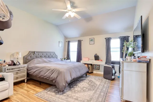 a bedroom with a bed a large window and flat screen tv