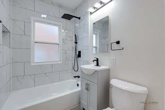 a bathroom with a sink a toilet and shower