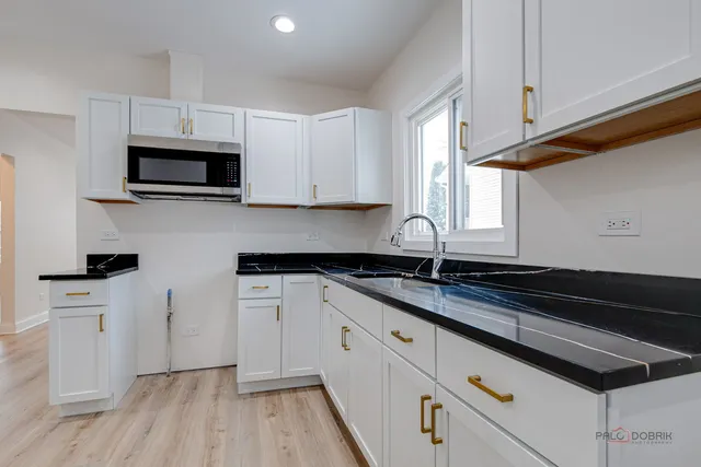 a kitchen with granite countertop a sink a stove and cabinets
