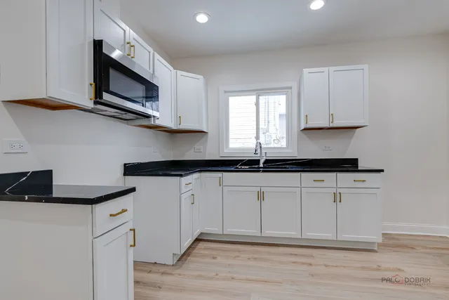 a kitchen with stainless steel appliances granite countertop a sink a stove a microwave and cabinets