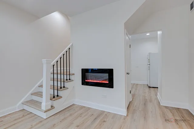 a view of a hallway with wooden floor and stairs