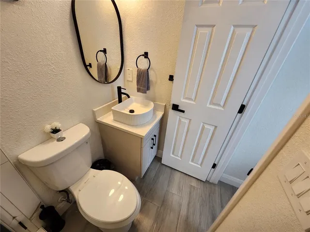 a bathroom with a sink and mirror with toilet