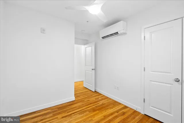 a view of a room with wooden floor and a ceiling fan