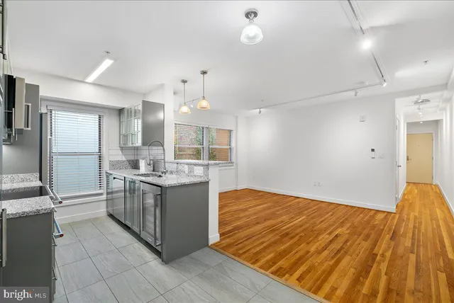 a kitchen with kitchen island granite countertop a sink cabinets and stainless steel appliances