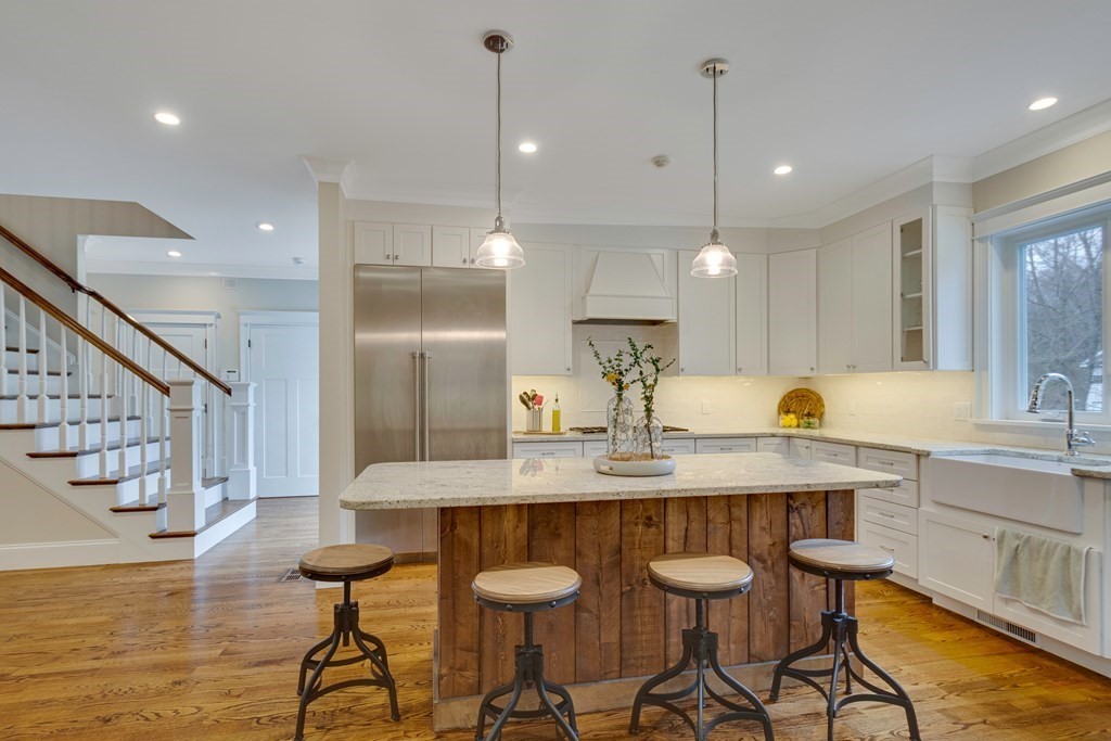 324 Concord Road Bedford, MA 01730 - Photo 14 of 42 a kitchen with granite countertop a table chairs stove a sink and dishwasher