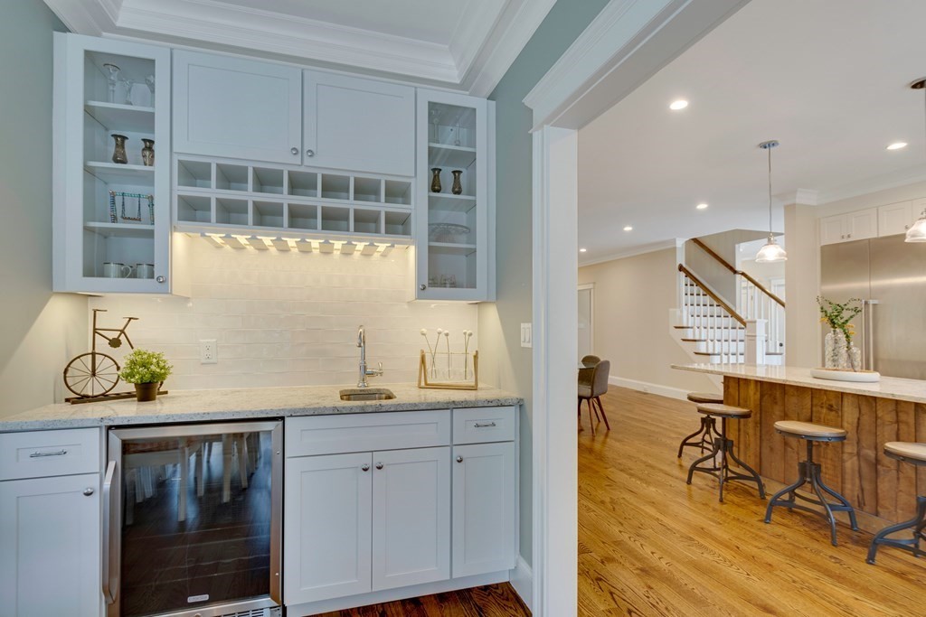 324 Concord Road Bedford, MA 01730 - Photo 23 of 42 a hallway with a dining table chairs and chandelier