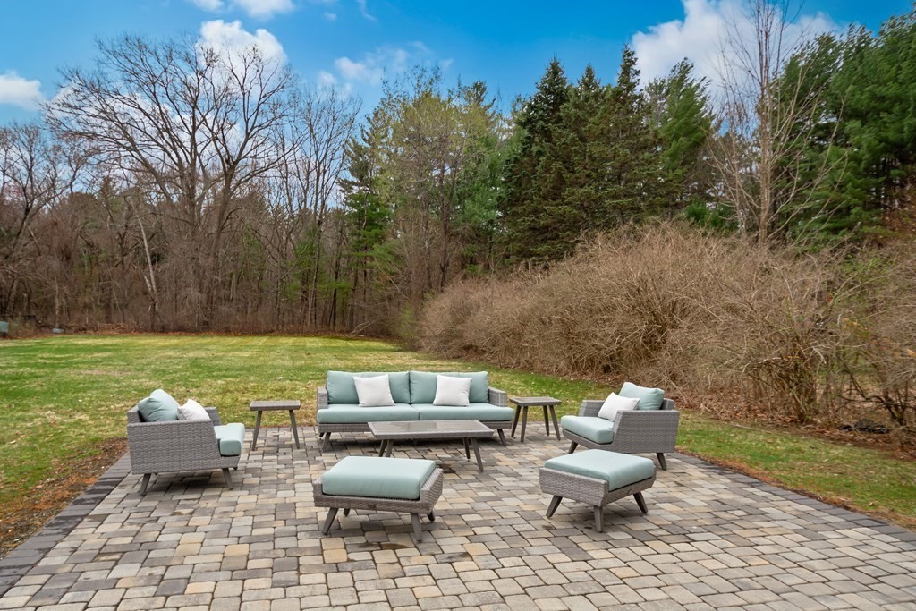 324 Concord Road Bedford, MA 01730 - Photo 39 of 42 a view of a backyard with lawn chairs and a fire pit