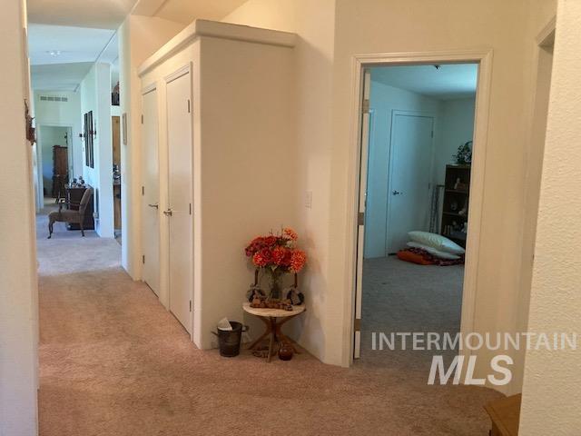 1095 County Road 70 Weiser, ID 83672 - Photo 24 of 44 Carpeted hallway with a built-in storage cabinet featuring two doors and a high shelf