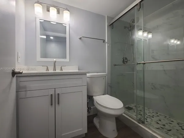 a bathroom with a sink a toilet and shower