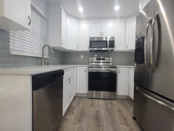 a kitchen with stainless steel appliances granite countertop a stove a refrigerator and a sink