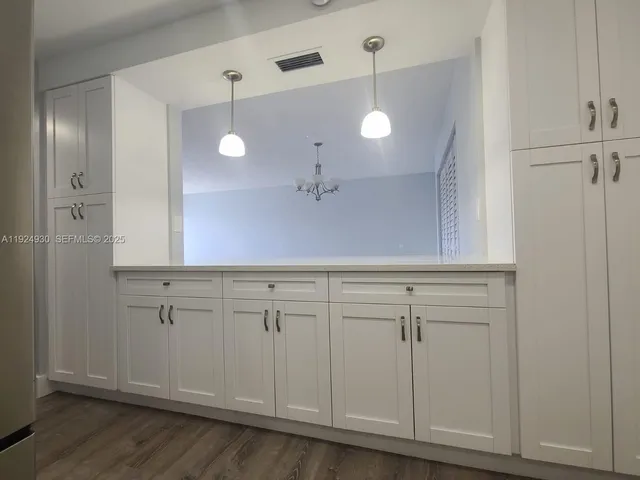 a view of a kitchen with white cabinets