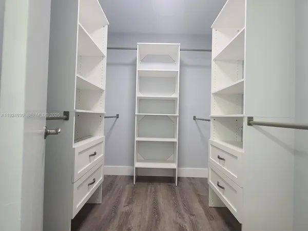 a view of walk in closet with empty racks