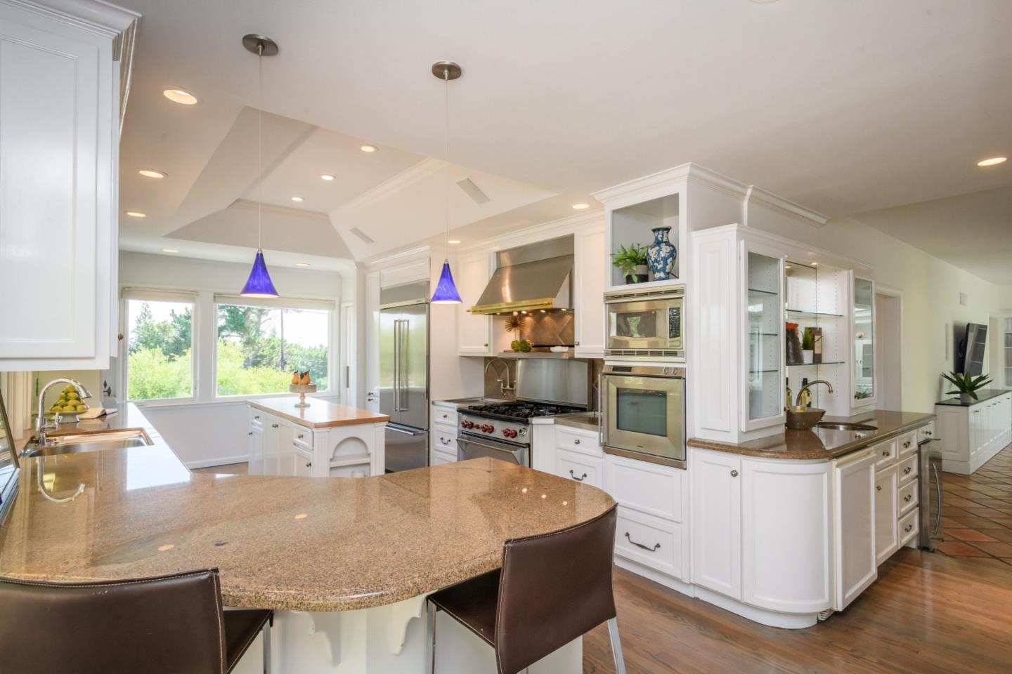 835 Longview Road Hillsborough, CA 94010 - Photo 21 of 46 a room with stainless steel appliances kitchen island granite countertop a table chairs and a refrigerator