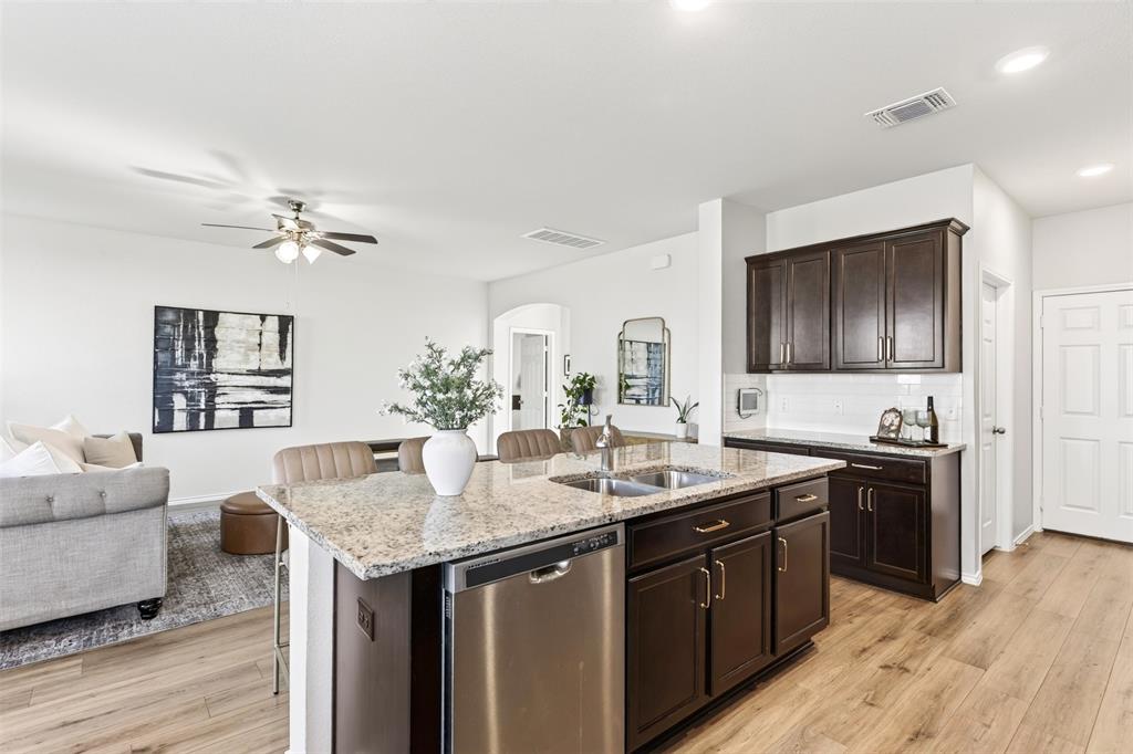 3105 Marston Road Lorena, TX 76655 - Photo 13 of 40 Kitchen island featuring a double-basin stainless steel sink, integrated stainless steel dishwasher, and a light-toned countertop