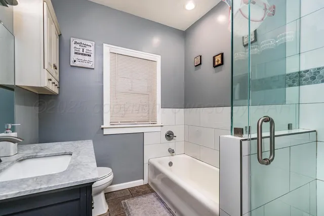 a bathroom with a granite countertop sink a toilet and bathtub