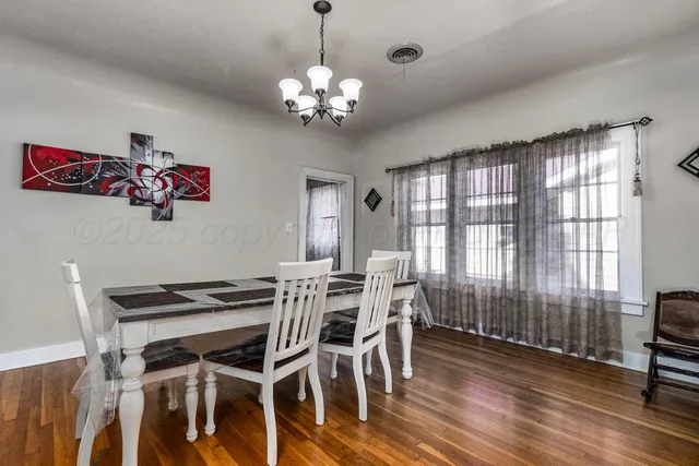a view of a dining room with furniture a chandelier and wooden floor